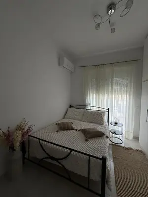 a bed in a white room with a window at Katsaras House 3 Cozy Bedrooms in Kremasti
