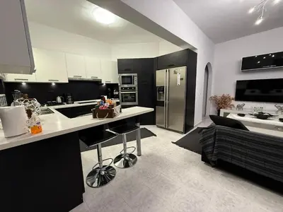 a black and white kitchen with a counter and a couch at Katsaras House 3 Cozy Bedrooms in Kremasti
