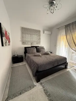 a bedroom with a bed and two rugs at Katsaras House 3 Cozy Bedrooms in Kremasti