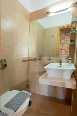 a bathroom with a white sink and a mirror at Villa CostaMare - enjoy lazy days on the private Pool-Jacuzzi in Pefki Rhodes