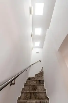 a staircase in a building with white walls and wooden stairs at Villa CostaMare - enjoy lazy days on the private Pool-Jacuzzi in Pefki Rhodes