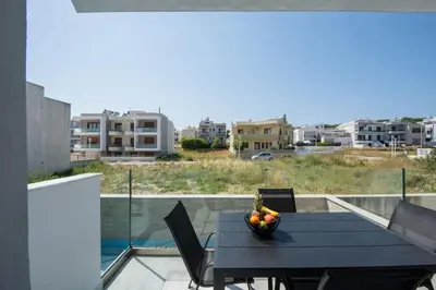 a black table with a bowl of fruit on a balcony at Santa Marina Luxury Apartments #2 with pool in Asgourou