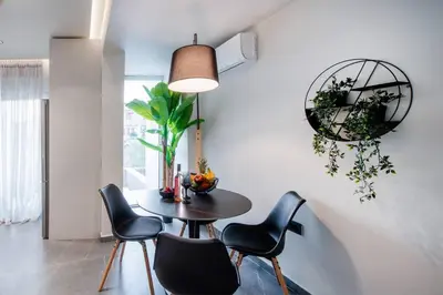 a dining room with a black table and chairs at Santa Marina Luxury Apartments #2 with pool in Asgourou