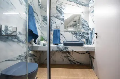 a bathroom with a sink and a toilet and a mirror at Santa Marina Luxury Apartments #2 with pool in Asgourou