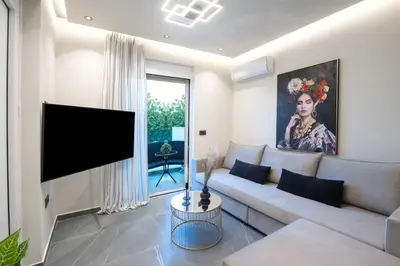 a living room with a couch and a flat screen tv at Santa Marina Luxury Apartments #2 with pool in Asgourou