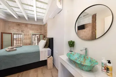 a bedroom with a bed and a mirror and a sink at 4 Bedroom luxury home - Villa SoZoe in Rhodes Town