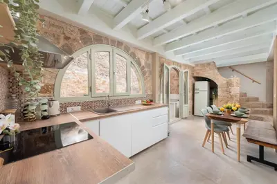 a kitchen with white cabinets and a table and chairs at 4 Bedroom luxury home - Villa SoZoe in Rhodes Town