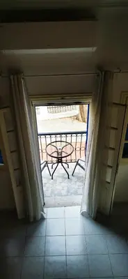 a door leading to a patio with a table on a balcony at Duchess House in Symi