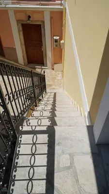a stairway leading up to a door with a shadow at Duchess House in Symi