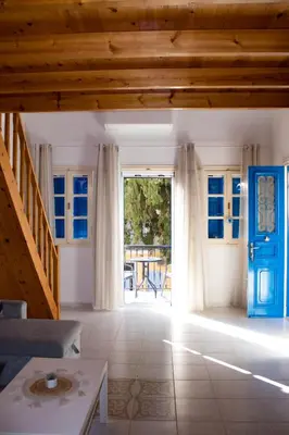 a living room with a blue door and a table at Duchess House in Symi