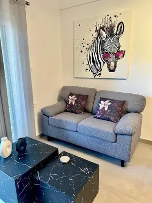 a living room with a couch and a zebra picture at Nice n Cosy Apartment II in Rhodes Town