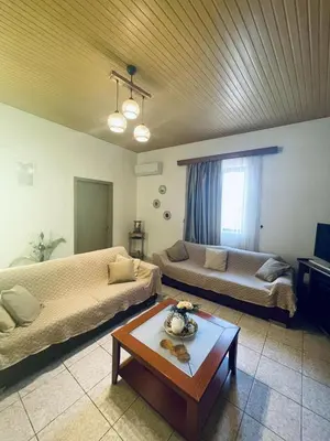 a living room with two beds and a table at Trachos Traditional House in Sálakos