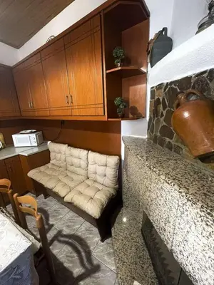 a living room with a couch and wooden cabinets at Trachos Traditional House in Sálakos
