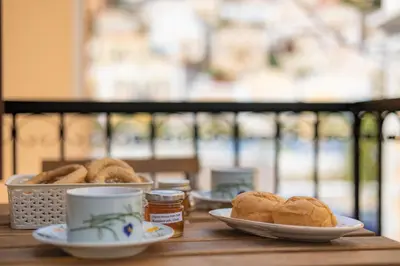 a table with plates of bread and a cup of coffee at Kantirimi House - A2 in Symi