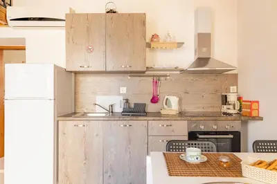 a kitchen with wooden cabinets and a white refrigerator at Kantirimi House - A2 in Symi