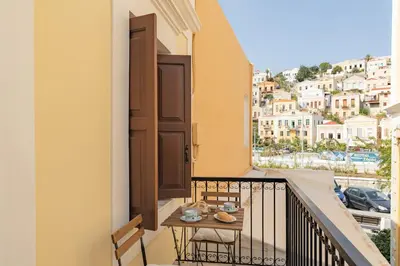 a balcony with a table and a view of a city at Kantirimi House - A2 in Symi