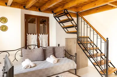 a living room with a couch and a spiral staircase at Kantirimi House - A2 in Symi