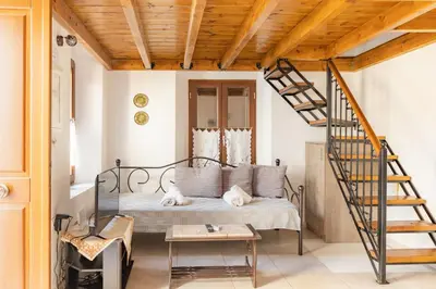 a bedroom with a bed and a spiral staircase at Kantirimi House - A2 in Symi