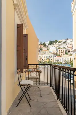 a balcony with a table and chairs and a view at Kantirimi House - A2 in Symi