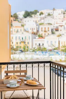 a table with bread and coffee on a balcony at Kantirimi House - A2 in Symi