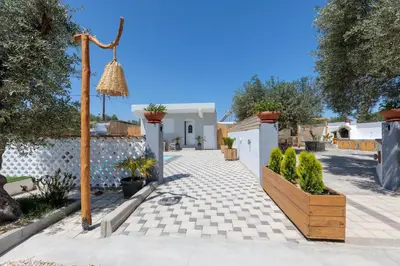a courtyard with a white fence and plants at Alamia Suites in Archangelos