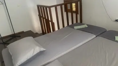 a bed with white sheets and a wooden chair at Isola Studio 2 in Rhodes Town