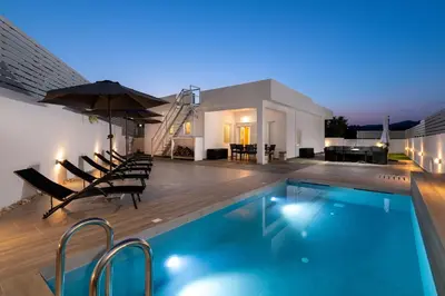 a swimming pool with chairs and an umbrella on a house at Villa Olea in Archipolis