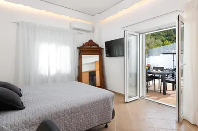 a bedroom with a bed and a sliding glass door at Villa Olea in Archipolis