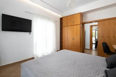 a bedroom with a bed and a flat screen tv at Villa Olea in Archipolis