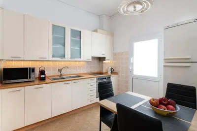 a kitchen with white cabinets and a table with a bowl of fruit at Villa Olea in Archipolis