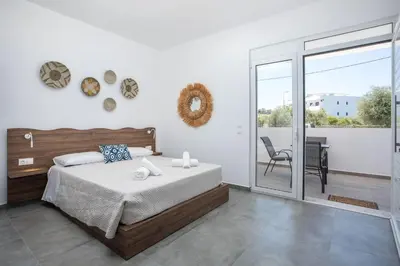 a bedroom with a bed and a balcony at Faliraki Harmony Apartments in Faliraki