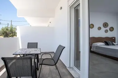 a balcony with a table and chairs and a bed at Faliraki Harmony Apartments in Faliraki