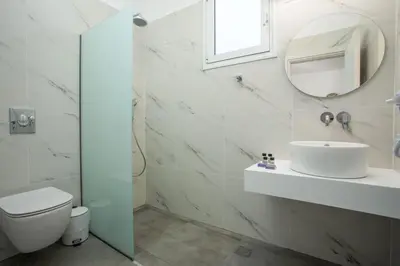 a white bathroom with a sink and a mirror at Faliraki Harmony Apartments in Faliraki