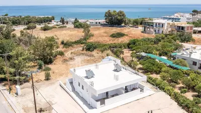 an aerial view of a white house with the ocean in the background at Faliraki Harmony Apartments in Faliraki
