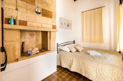 a bedroom with a bed and a brick wall at Mary's house Lindos in Líndos