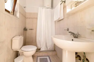 a bathroom with a white toilet and a sink at Mary's house Lindos in Líndos