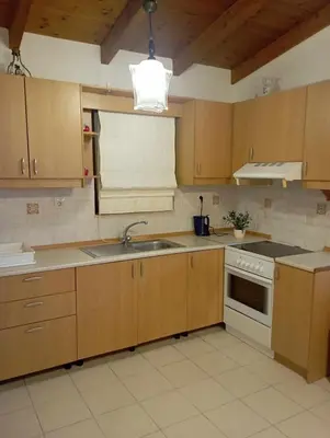 a kitchen with wooden cabinets and a sink and a stove at Katavias House in Kattavía