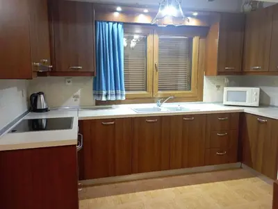 a kitchen with wooden cabinets and a sink and a microwave at Katavias House in Kattavía