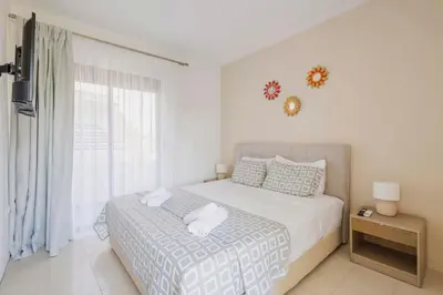 a white bedroom with a bed and a window at Villa Bella Natura in Afantou