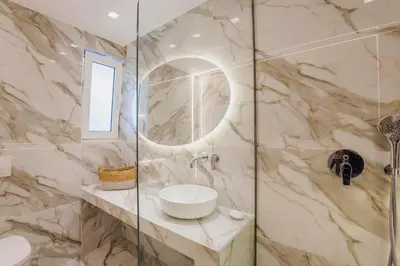 a bathroom with a shower with a sink and a mirror at Villa Bella Natura in Afantou
