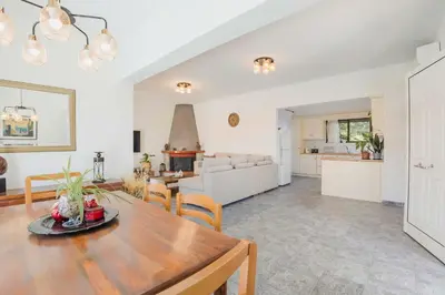 a living room with a dining room table and a kitchen at Villa Bella Natura in Afantou