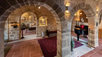 a room with a stone archway with a piano at Kókkini Porta Rossa in Rhodes Town
