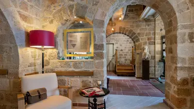 a living room with a chair and a red lamp at Kókkini Porta Rossa in Rhodes Town