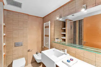 a bathroom with a sink and a toilet and a mirror at Veranna Lux Apartment in Ialyssos