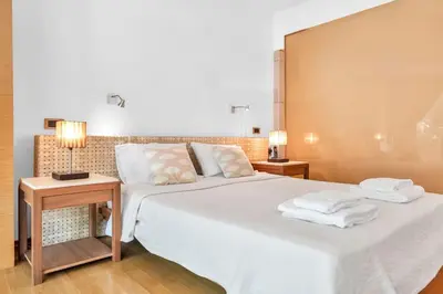 a bedroom with a large white bed with towels on it at Veranna Lux Apartment in Ialyssos
