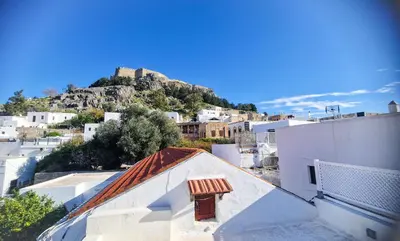 a view of a city with a castle on a mountain at Unique Stes Lindos in Líndos
