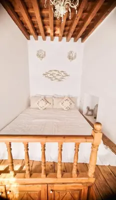 a bed in a room with a wooden table at Unique Stes Lindos in Líndos