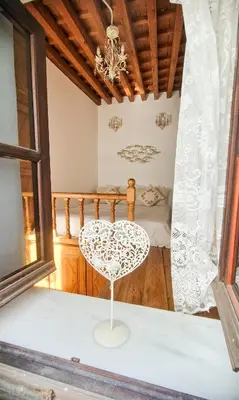 a white chair sitting in a room with a bed at Unique Stes Lindos in Líndos
