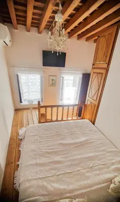 a bedroom with a large bed with a chandelier at Unique Stes Lindos in Líndos