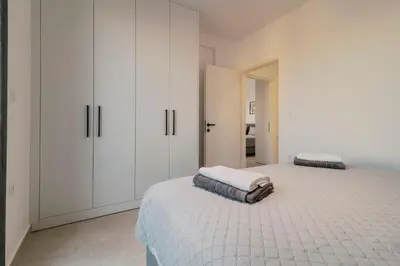 a white bedroom with white cabinets and a bed at Koskinou Escape Villa in Koskinou